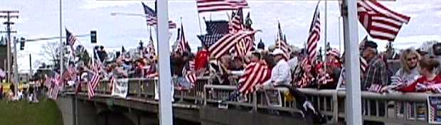 many people and flags on overpass