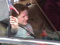 girl in car waving flag